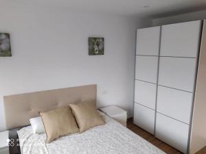 um quarto com uma cama branca e um armário branco em EL MEJICANO II em Trevías