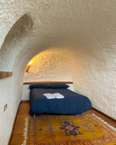 - un lit dans une petite chambre avec plafond dans l'établissement CASA CUEVA PIENA, Alcudia de Guadix, à Alcudia de Guadix
