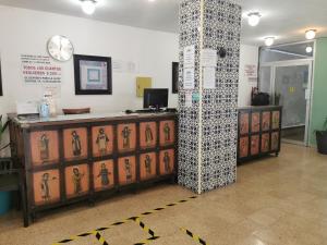 a store lobby with a counter and a clock on the wall at Hotel Las Dalias Inn in M&eacute;rida