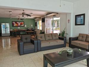 a living room with two couches and a table at Hotel Las Dalias Inn in Mérida