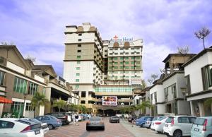 a city street with cars parked in front of a building at Aroma Hotel in Butterworth