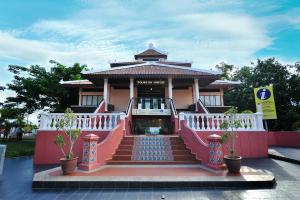 a pink building with a staircase leading to it at Fenix Inn in Malacca