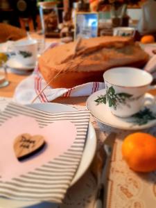 una mesa con platos y una taza y un pastel en HIŠA ANTONIJA-APARTMA IRINKA en Fokovci