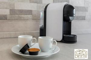 two cups on a plate next to a coffee maker at Ponte Milvio Suite in Rome
