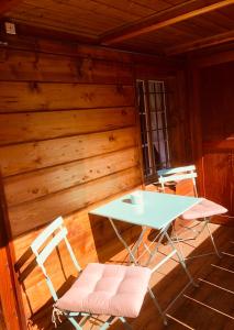 einen weißen Tisch und zwei Stühle in einer Hütte in der Unterkunft Gemütliches Zuhause mit Ausblick in Wilderswil