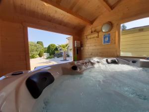 een groot bad in een kamer met een raam bij O' Bonheur de l'Olivier Chambres et Gîtes 4 étoiles in Cessenon