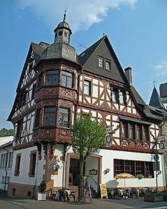 un grande edificio con una torre dell'orologio sopra di Hotel Spies a Gladenbach