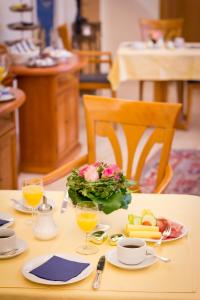 una mesa con un plato de comida y vasos de zumo de naranja en Hotel Spies, en Gladenbach