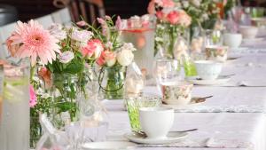 Spacube Luxury Suites and Spa في بريتوريا: طاولة مقدمة مع مزهريات مليئة بالورود الزهرية