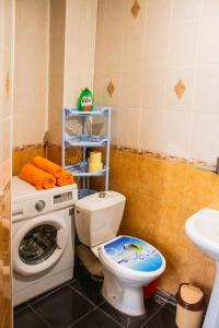 y baño con aseo y lavadora. en Уютная квартира в районе ХБК на ул.Ворошилова, д.29а en Shakhty