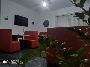 um quarto com uma mesa e duas cadeiras e uma televisão em Hostel de Luz - Unidade 1 em Campinas