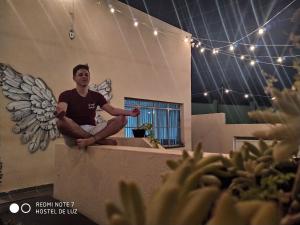 a man sitting on the ledge of a building at Hostel de Luz - Unidade 1 in Campinas +19 photos