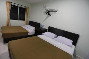 Postel nebo postele na pokoji v ubytování Tengkera Hotel