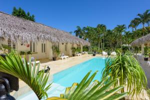 un complejo con piscina y palmeras en Adults-Only Hacienda Terra Taina, en Las Terrenas