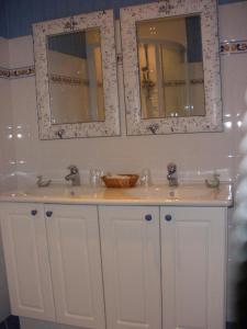 a bathroom with two sinks and two mirrors at Logis Saint Martin in Magny-lès-Villers