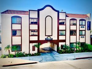 a large white building with a red roof at Days Inn by Wyndham Alhambra CA in Alhambra
