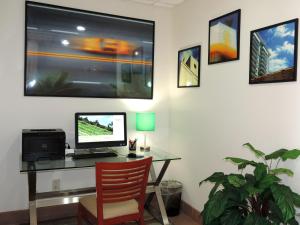 a living room with a computer desk and a painting on the wall at Floridian Hotel in Homestead