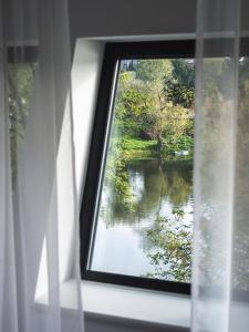 a view of a river from a window with a view at Hotel Termalny in Uniejow