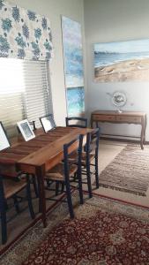 een eetkamer met een houten tafel en stoelen bij Siesta in Hermanus