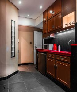uma cozinha com armários de madeira e bancadas vermelhas em NOHO Boutique Koukaki , premium living em Atenas