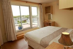 een slaapkamer met een bed en een groot raam bij Arus Grattan in Galway +19 foto's