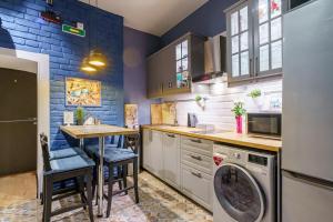 uma cozinha com uma máquina de lavar roupa e uma mesa em Adam`s House em São Petersburgo