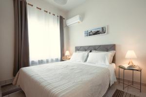a bedroom with a white bed and a large window at Bay View in Limenas