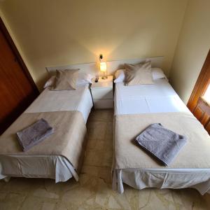 2 camas en una habitación pequeña con una lámpara en una mesa en H Los Rafaeles en Torrejón de Ardoz