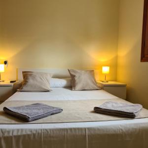 a bed with two towels on top of it at H Los Rafaeles in Torrejón de Ardoz