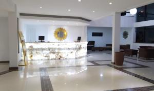 um lobby com um espelho de ouro na parede em Sueds Segundo Sol em Santa Cruz Cabrália