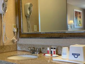 a bathroom sink with a phone and a mirror at Days Inn by Wyndham Alhambra CA in Alhambra +18 photos