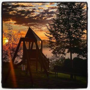 a playground with a slide and a bench at sunset at La Fattoria Montalcinello in Chiusdino