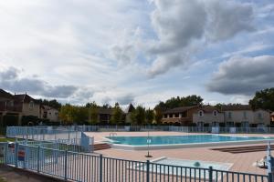 a large swimming pool with a fence around it at Appartement avec vue magnifique sur le Lac de Monflanquin in Monflanquin