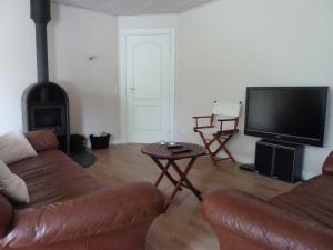sala de estar con sofá y TV de pantalla plana en Snehvide Bed & Breakfast, en Thisted