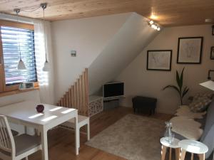 a living room with a white table and a tv at Ferienwohnung Kapellenweg Bambergen bei Überlingen in Bambergen