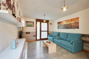 ein Wohnzimmer mit einem blauen Sofa und einem Tisch in der Unterkunft El Patio de la Catedral in Salamanca