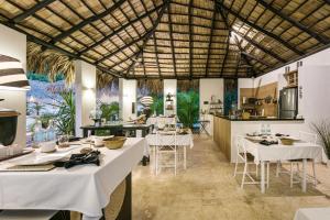 um restaurante com mesas brancas e uma cozinha em Adults-Only Hacienda Terra Taina em Las Terrenas