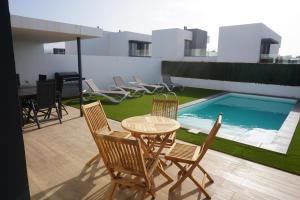a patio with chairs and a table and a swimming pool at Casa Soleada in La Oliva