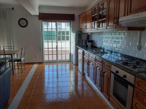 a kitchen with wooden cabinets and a table with a dining room at Casa O'lado in Golegã