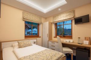 a bedroom with a bed and a desk with a computer at Na kraji lesa in Valašské Meziříčí