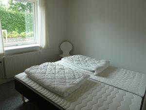 1 cama no hecha en un dormitorio con ventana en Snehvide Bed & Breakfast, en Thisted