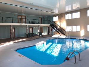a large swimming pool in a large building at Super 8 by Wyndham Plover Stevens Point Area in Plover
