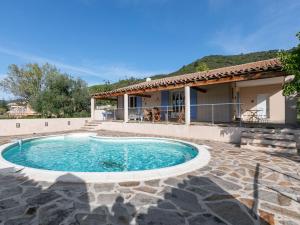 a villa with a swimming pool in front of a house at Cozy Villa in Roquebrun with Private Pool in Roquebrun