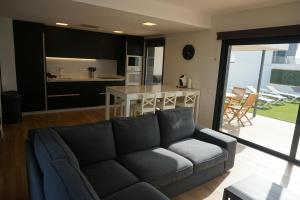 a living room with a couch and a kitchen at Casa Soleada in La Oliva