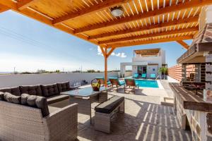 a patio with furniture and a swimming pool at Kallipateira Villa in Lachania