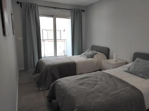 a bedroom with two beds and a window at Eanes 22 beach house in Monte Gordo