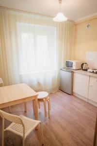 a room with a table and a kitchen with a table and chairs at Навигатор - Апартаменты Аэропорт Красноярск in Yemel'yanovo