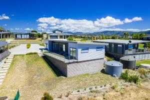 an image of a house with a yard at Dune Views - Mangawhai Heads Holiday Home in Mangawhai