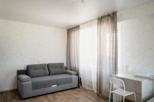 a living room with a couch and a desk at Навигатор - Апартаменты Аэропорт Красноярск in Yemel'yanovo