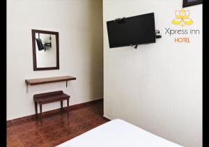a room with a bed and a tv on a wall at Xpress Inn Hotel in Veracruz